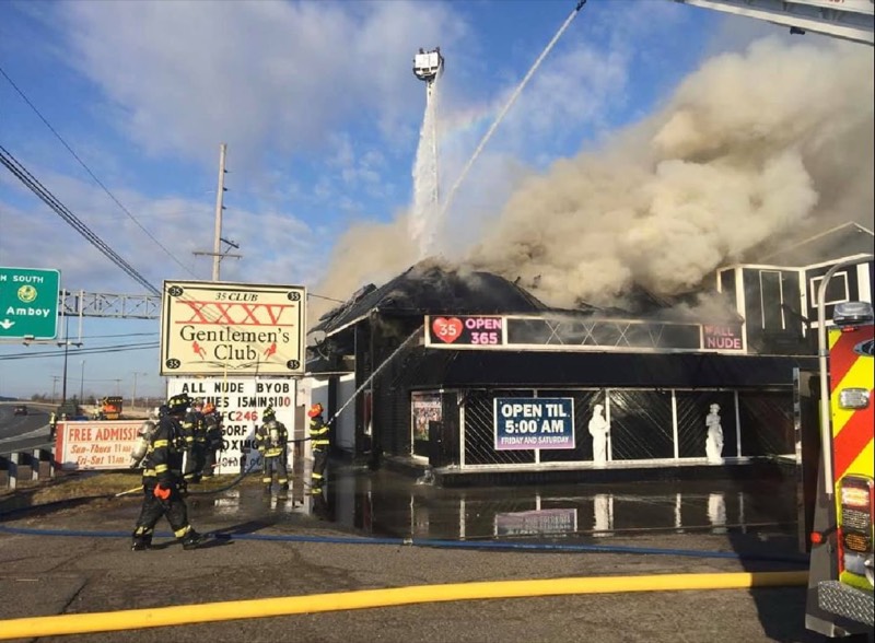 Water streams arcing onto a smoking commercial building